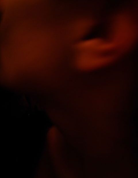 Autorretrato en penumbra roja de Roser Amills: su oreja y su perfil desnudos, 2008