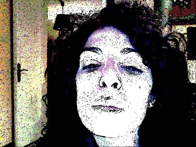Autorretrato de Roser Amills con efecto de trama de puntos, mirando de frente con los labios cerrados