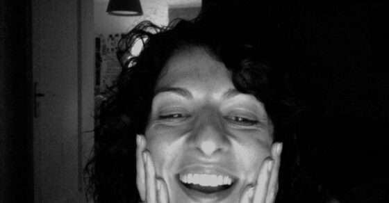 Autorretrato en blanco y negro de Roser Amills riendo, con las manos en las mejillas