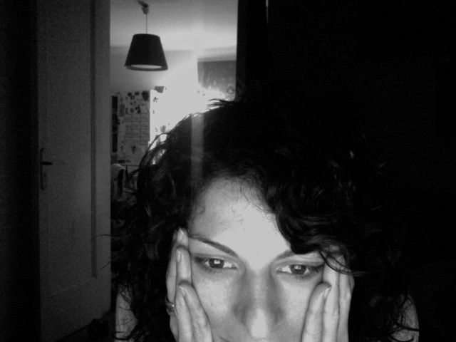 Autorretrato en blanco y negro de Roser Amills con las manos en las mejillas y la mirada baja