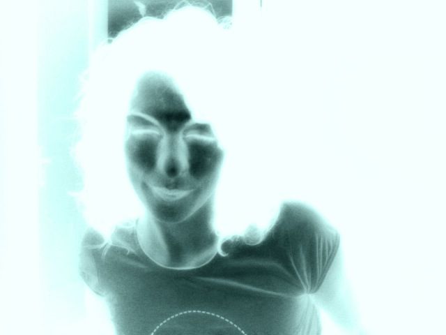 Autorretrato de Roser Amills con efecto de negativo, azul y blanco, tomado con la webcam
