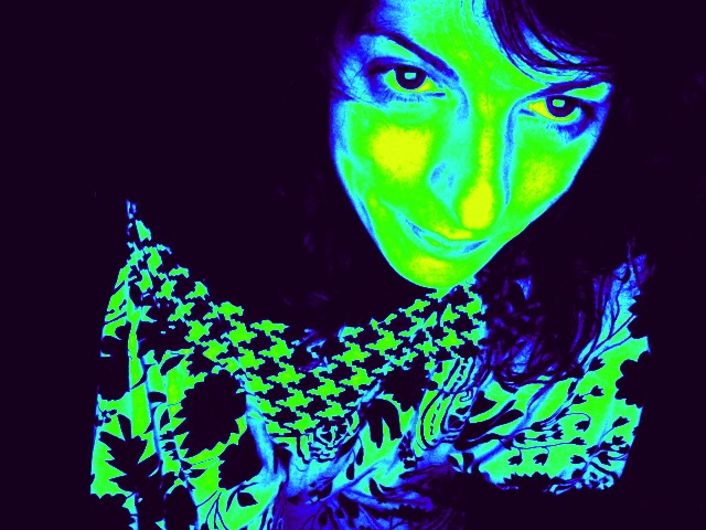 Autorretrato de Roser Amills con colores saturados en verde, amarillo y azul y una mirada intensa