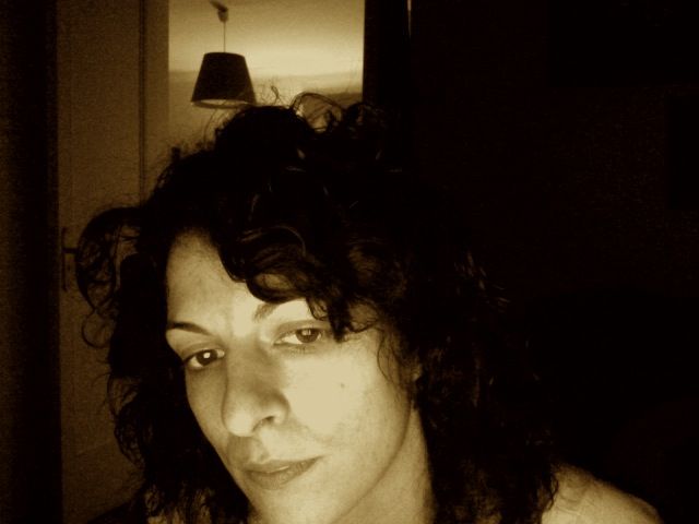 Retrato en sepia de Roser Amills con el pelo rizado, mirando de lado