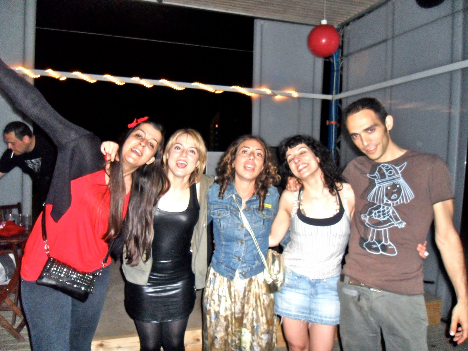 Cinco amigos posando abrazados bajo una guirnalda de luces en la Erotic Soirée