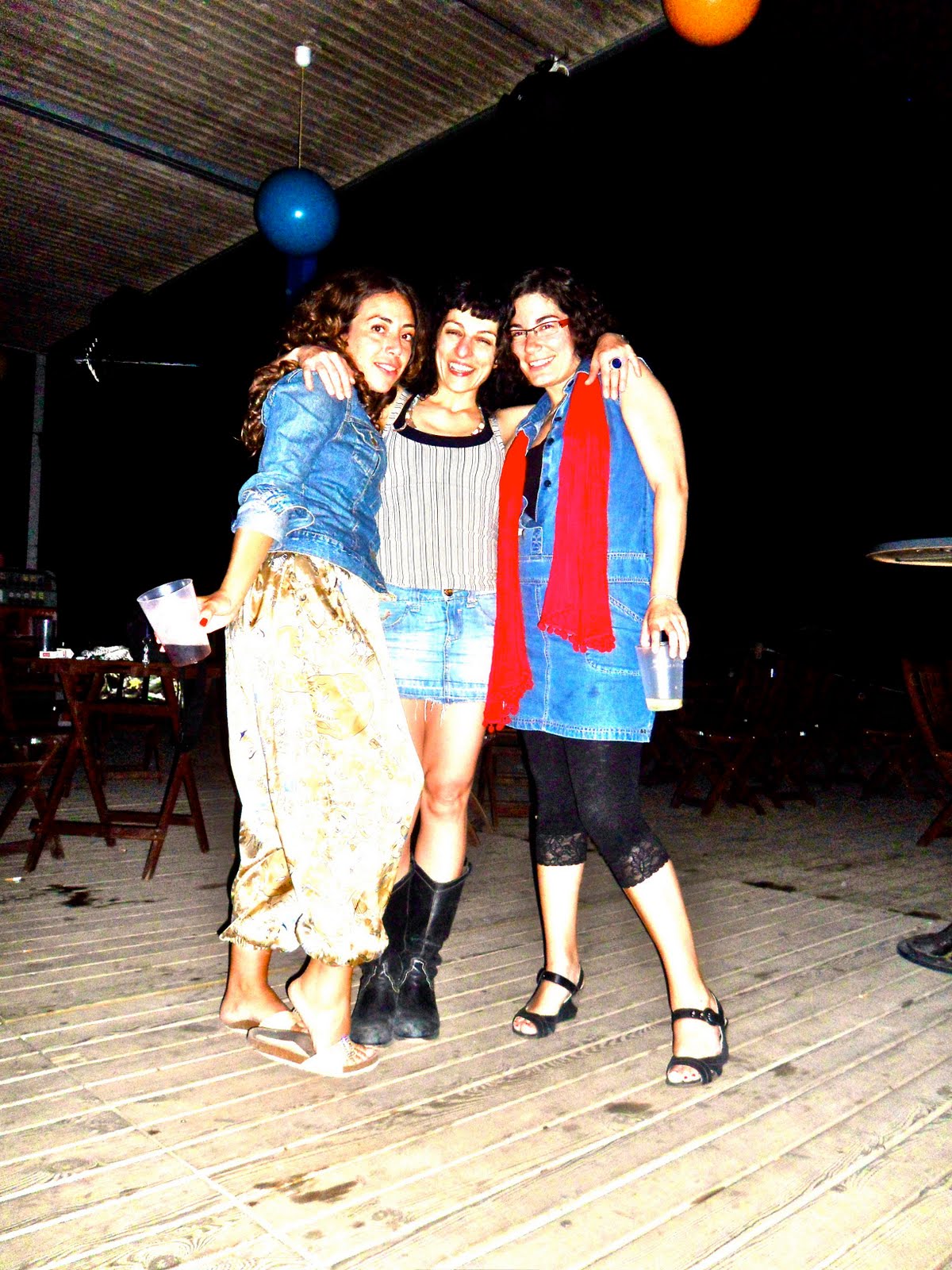 Tres amigas posando abrazadas en la terraza de madera de la Erotic Soirée