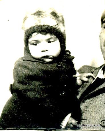 Roser Amills de bebè, amb gorro de llana i abric fosc, en una fotografia de fotomatón
