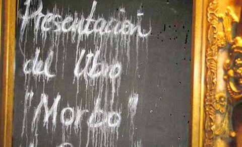 Pissarra amb marc daurat on es llegeix, escrit amb guix, «Presentación del libro «Morbo» de Roser Amills»