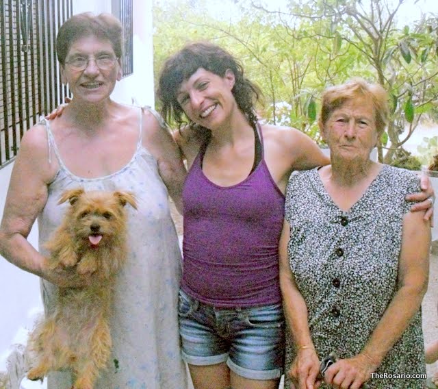 Damiana, Roser Amills i Catalina, amb un gosset als braços, davant d'una casa a Algaida