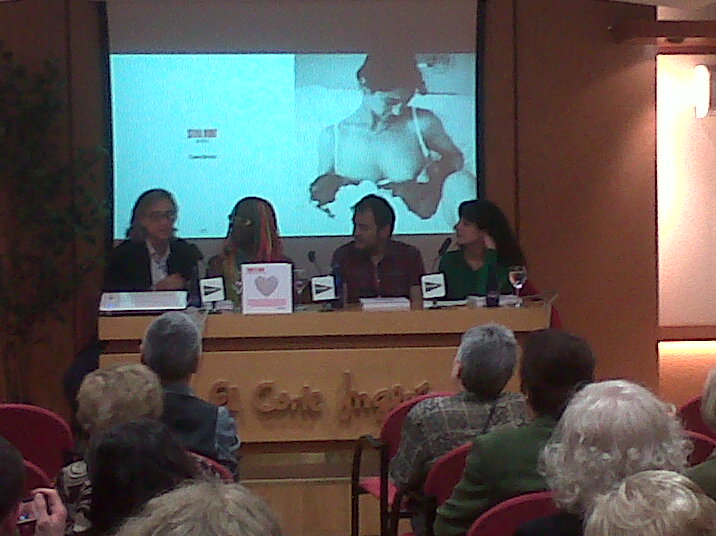 Quatre persones assegudes darrere una taula de presentació a la sala Àmbit Cultural d'El Corte Inglés, amb públic en primer terme i una pantalla al fons