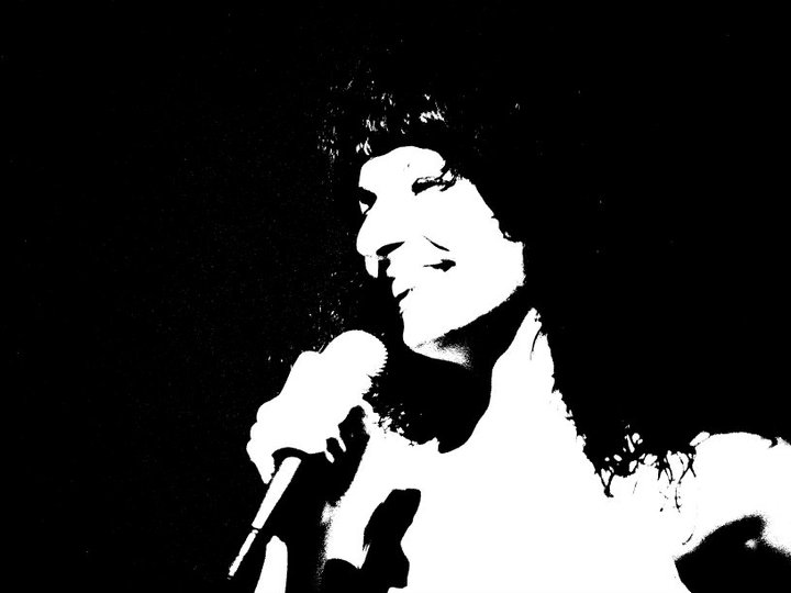 Silueta en blanc i negre d'una dona de cabell arrissat amb un micròfon a la mà, en un contrast molt alt