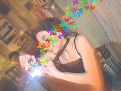 Roser Amills asseguda en una sala plena de llibres, amb una càmera de fotos i papallones de colors