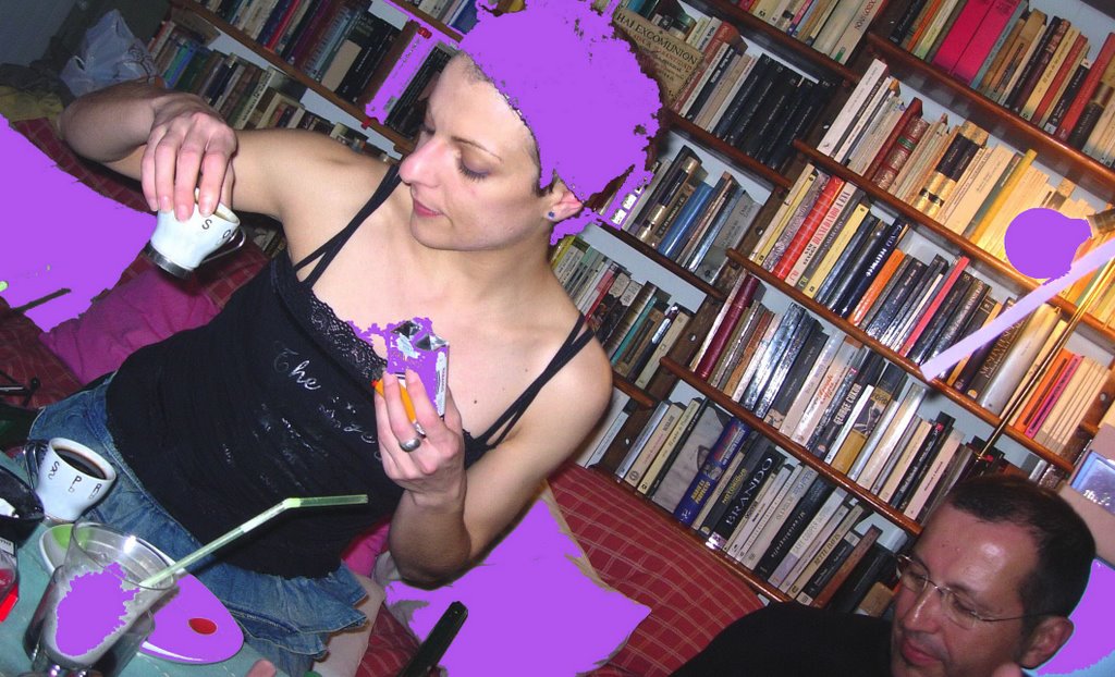 Roser Amills asseguda entre llibres amb un mòbil a la mà, fotografia retocada en lila