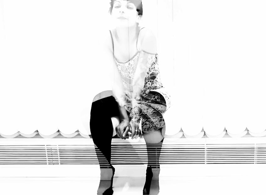 Roser Amills asseguda en blanc i negre amb mitgetes altes i talons, en doble exposició, fotografia d'Ana Coello