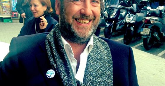 Emili Manzano sonriendo con el pin de «M'agrada el sexe» en la solapa, en la calle
