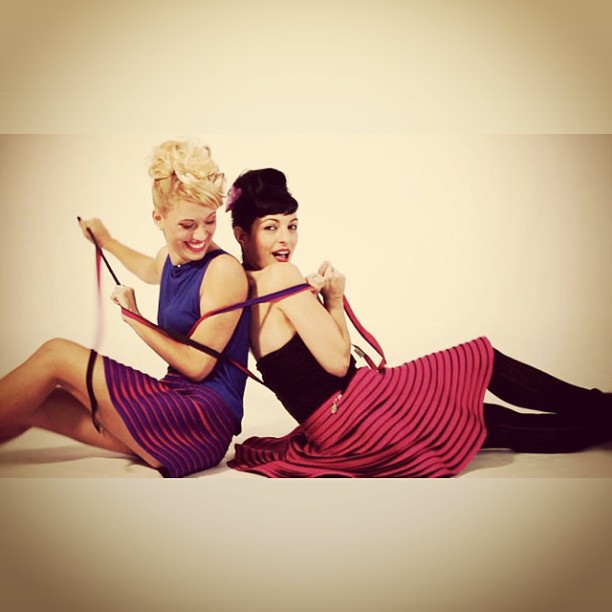 Dos mujeres posando juguetonas con falda, en un retrato de estudio