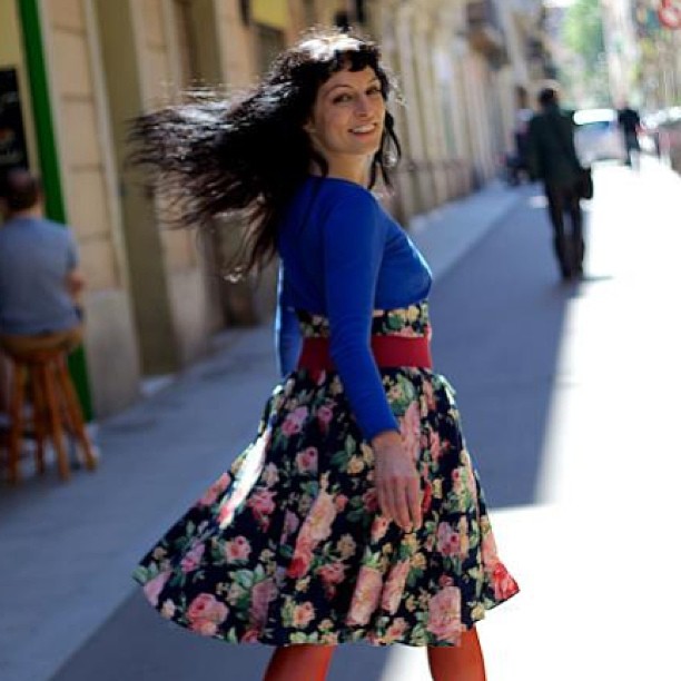 Roser Amills girando con el pelo al viento en una calle de Barcelona, con vestido de flores