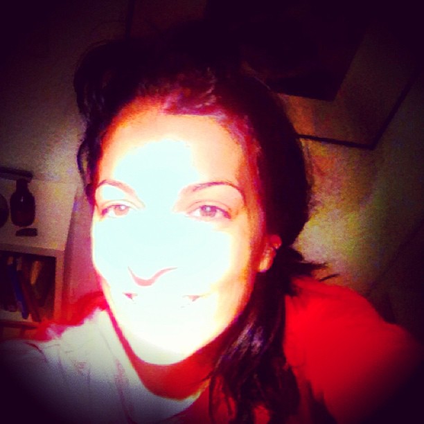Autorretrato de Roser Amills con una luz blanca sobre el rostro y jersey rojo