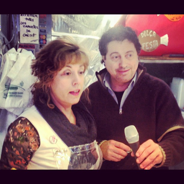 Una vendedora y un vendedor de un mercado, ella hablando ante un micrófono