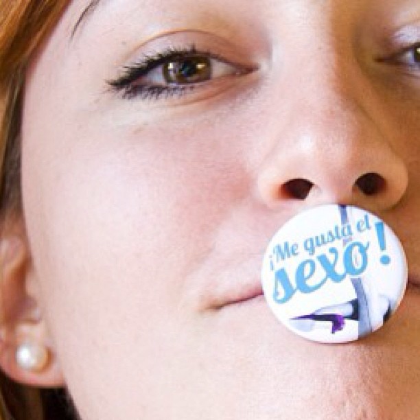 Detalle de un ojo y de una chapa de ¡Me gusta el sexo! sobre los labios