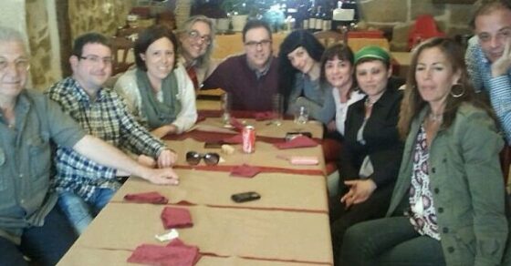 Comida de grupo en torno a una larga mesa en un restaurante de piedra