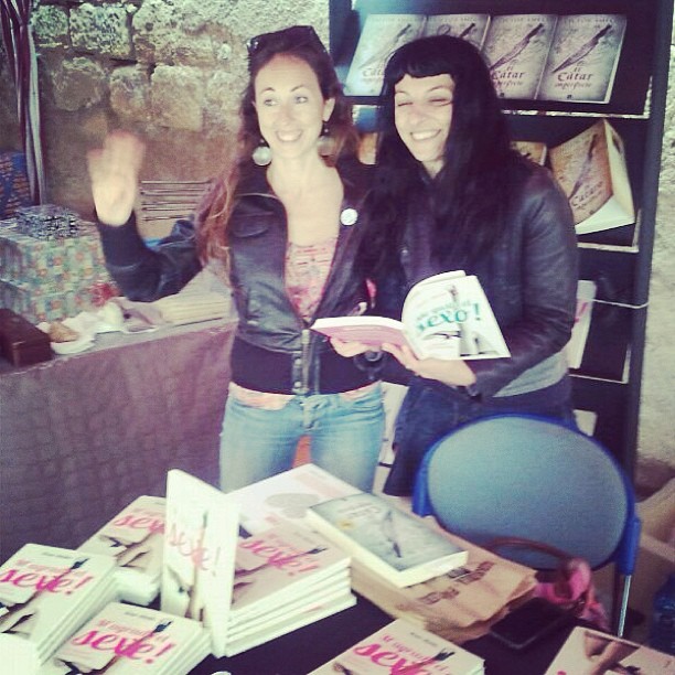 Cristina, lectora, saluda con un ejemplar de ¡Me gusta el sexo! junto a Roser Amills en la mesa de firmas de Arnes