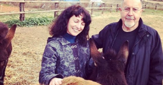 Roser Amills y Bigas Luna sonríen en el campo mientras acarician un burro