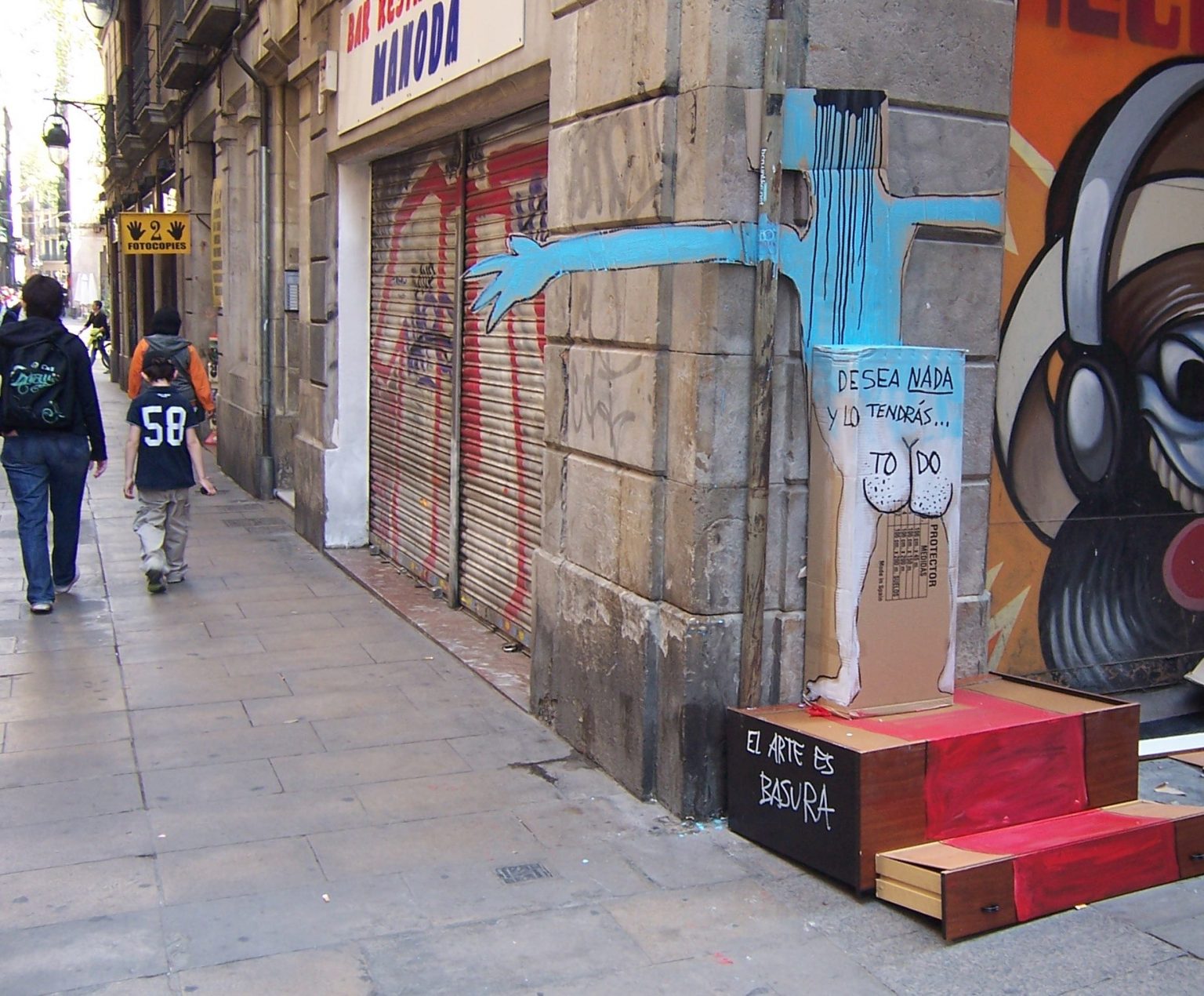 Obra de Francisco de Pájaro hecha con basura en una calle de Barcelona, con el lema «El arte es basura»