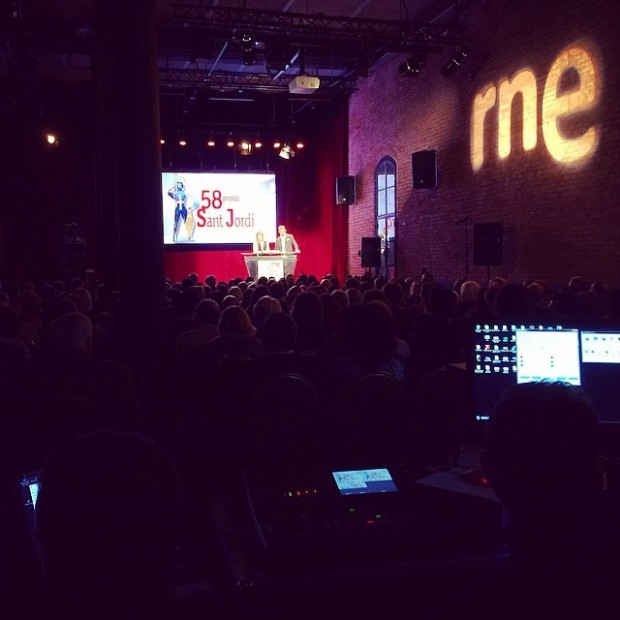 Sala de la antigua fábrica Estrella Damm con el escenario de la gala de los 58 Premis Sant Jordi y el logotipo de RNE