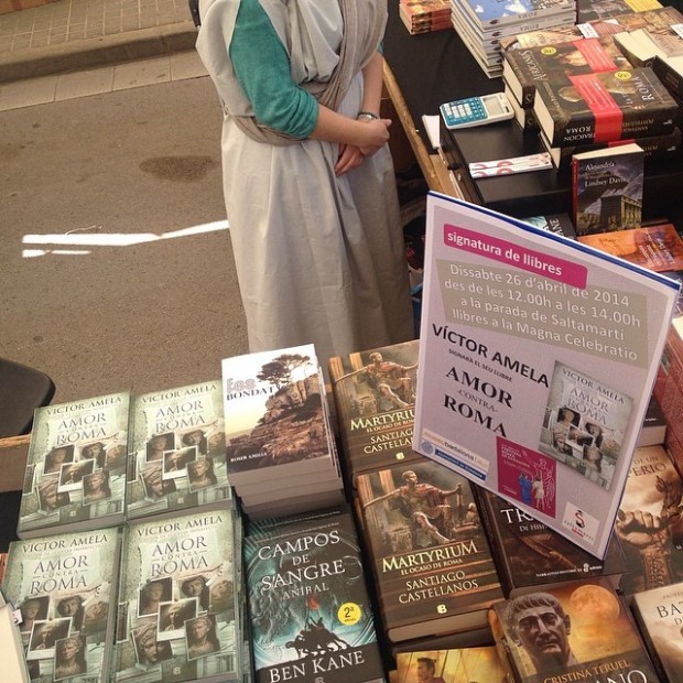 Parada de la librería SaltaMartí en Badalona con libros de Víctor Amela y el cartel de la firma de Amor contra Roma