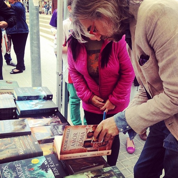 Víctor Amela firma un ejemplar de Amor contra Roma en una parada de libros