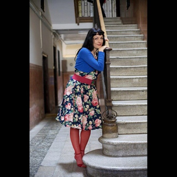 Roser Amills en una escalera, con vestido de flores, jersey azul y medias rojas