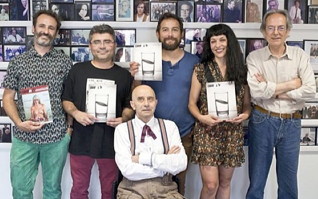 Seis personas posan delante de una pared de fotografías enmarcadas, varias con ejemplares de Canibaal; Roser Amills, con vestido de flores y flequillo, sostiene uno