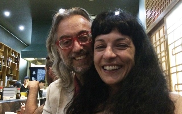 Selfi de Roser Amills y Víctor Amela con gafas rojas en un local