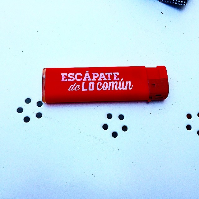 Mechero rojo con la frase «Escápate de lo común»