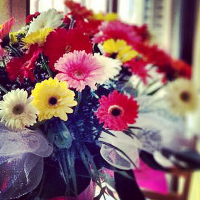 Ramo de gerberas rojas, rosas, amarillas y blancas con un lazo de tul