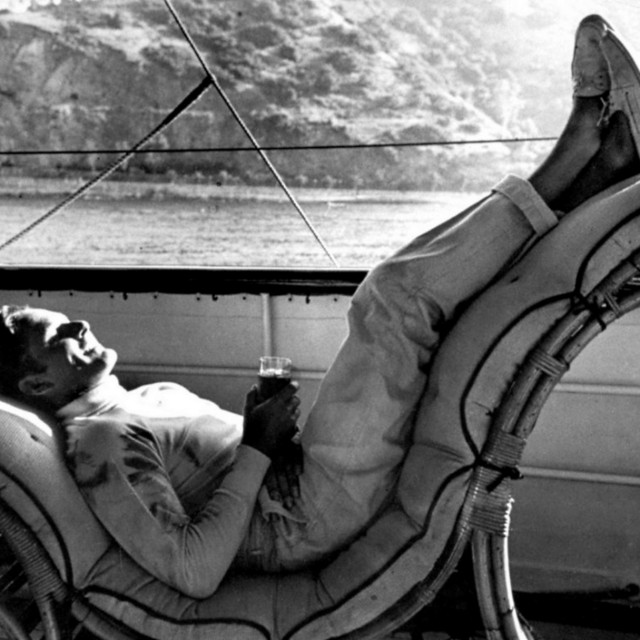 Errol Flynn tumbado en una hamaca de mimbre en la cubierta del Zaca, en blanco y negro