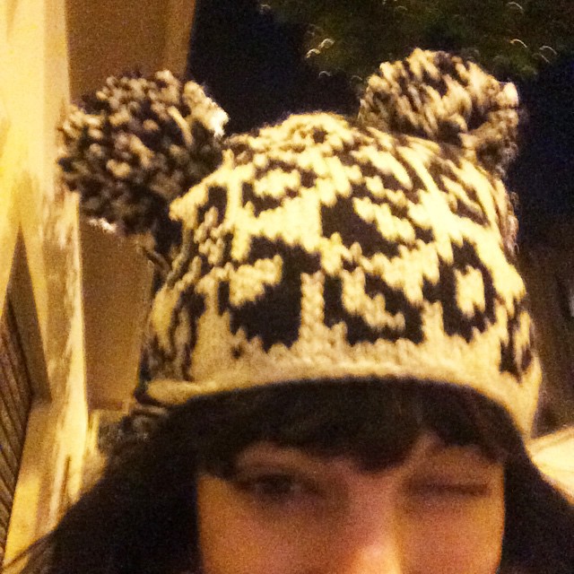Roser Amills guiñando un ojo con un gorro de lana blanco y negro con dos pompones