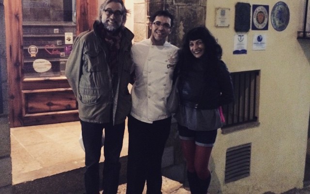 Víctor Amela, un cocinero con chaqueta blanca y Roser Amills de noche ante una fachada