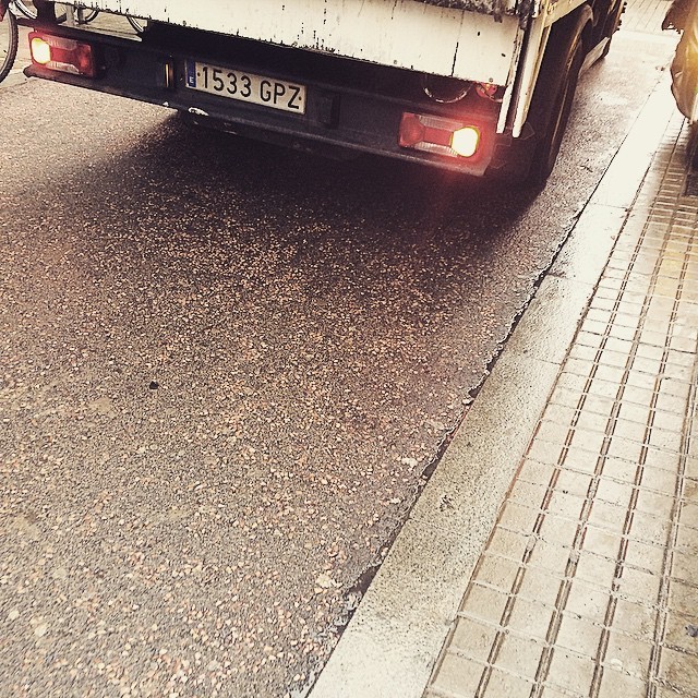 Carrer mullat de Barcelona amb una furgoneta aparcada, un matí d’hivern sense neu