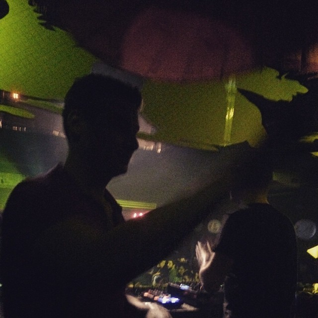 Silueta de un DJ bajo luces verdes en una discoteca de Barcelona de madrugada