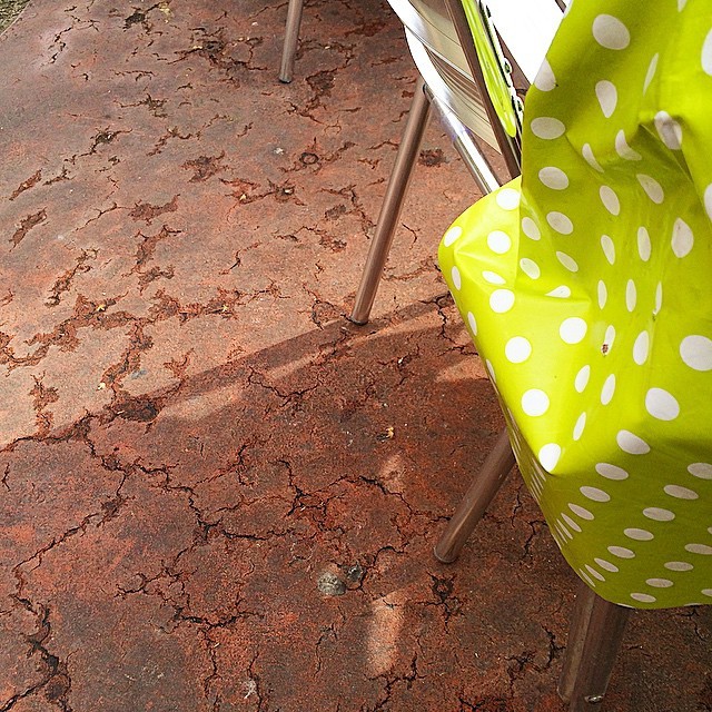 Suelo agrietado como un mapa junto a una silla de lunares verdes