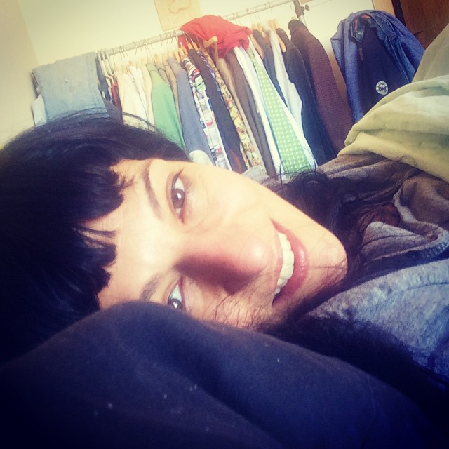 Roser Amills sonriente recostada junto a un perchero de ropa