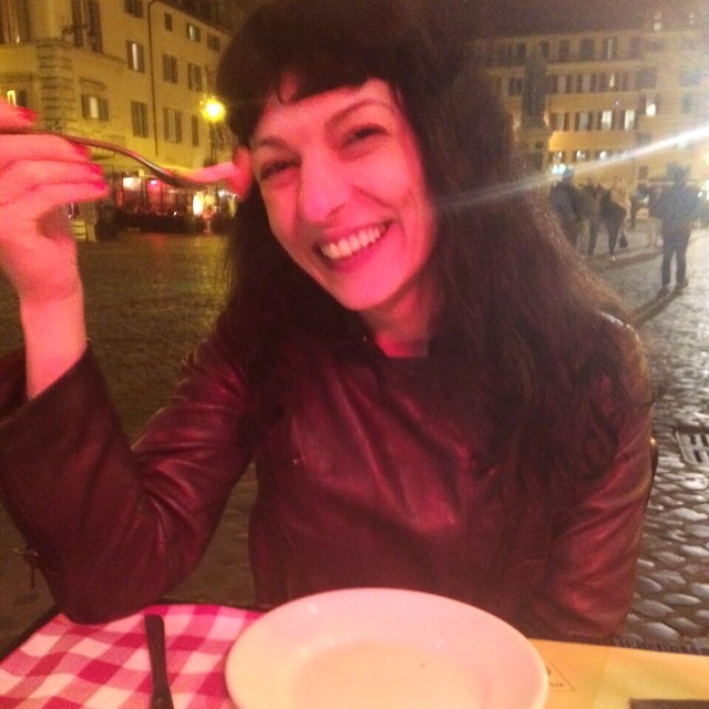 Roser Amills riendo en la terraza de una plaza de Roma por la noche