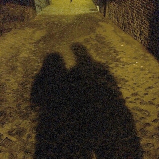 Sombras de Roser Amills y Víctor Amela sobre el empedrado de una calle de Roma