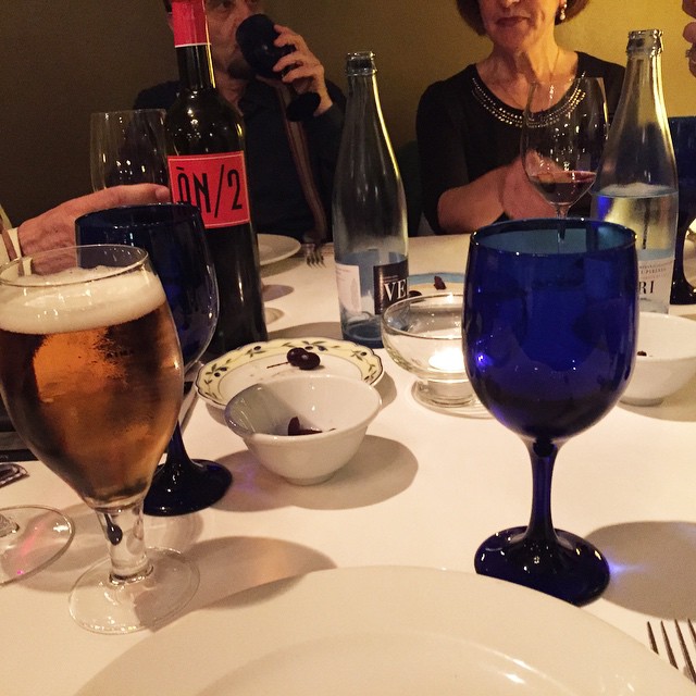 Mesa de la cena con una botella de Ànima Negra, cerveza y copas azules