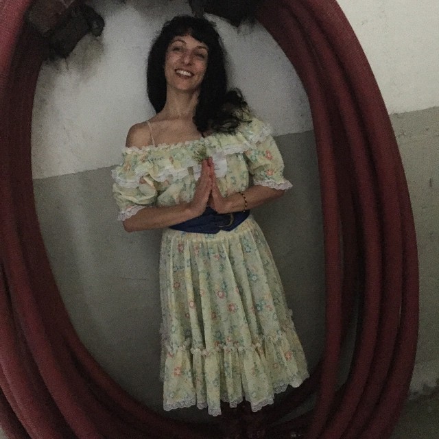 Roser Amills con vestido campestre de volantes y las manos juntas