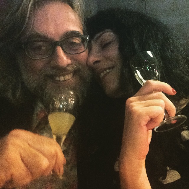 Roser Amills y Víctor Amela brindando con copas, mejilla con mejilla