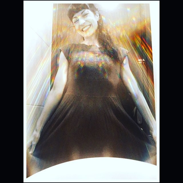 Roser Amills sonriendo, con un vestido oscuro, fotografiada desde abajo en un lavabo, con destellos de luz de colores
