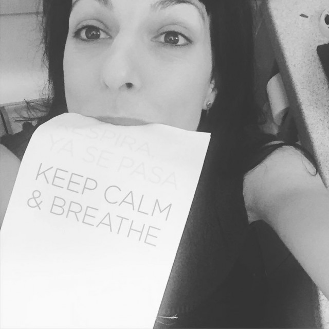 Autorretrato en blanco y negro de Roser Amills mordiendo un papel con el texto Respira, ya se pasa. Keep calm & breathe