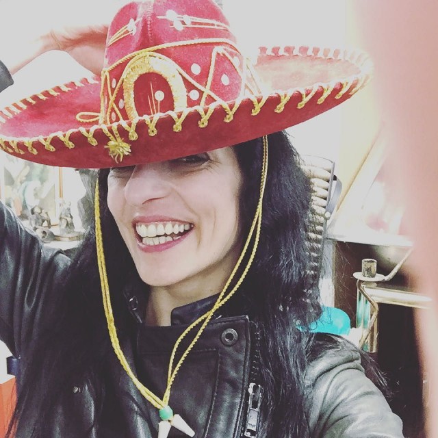 Autorretrato sonriente con un sombrero mexicano rojo y una chaqueta de cuero negra